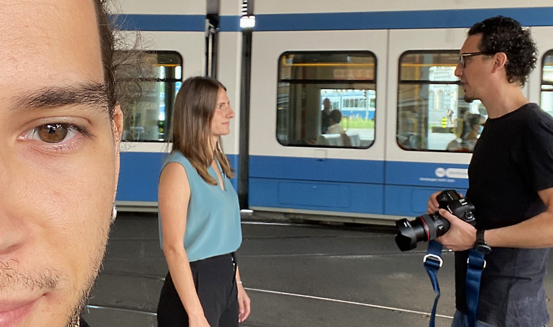 Jans Kopf ist links zu sehen. Im Hintergrund spricht Fotograf Mirco mit Fiona, ein Tram fährt vorbe