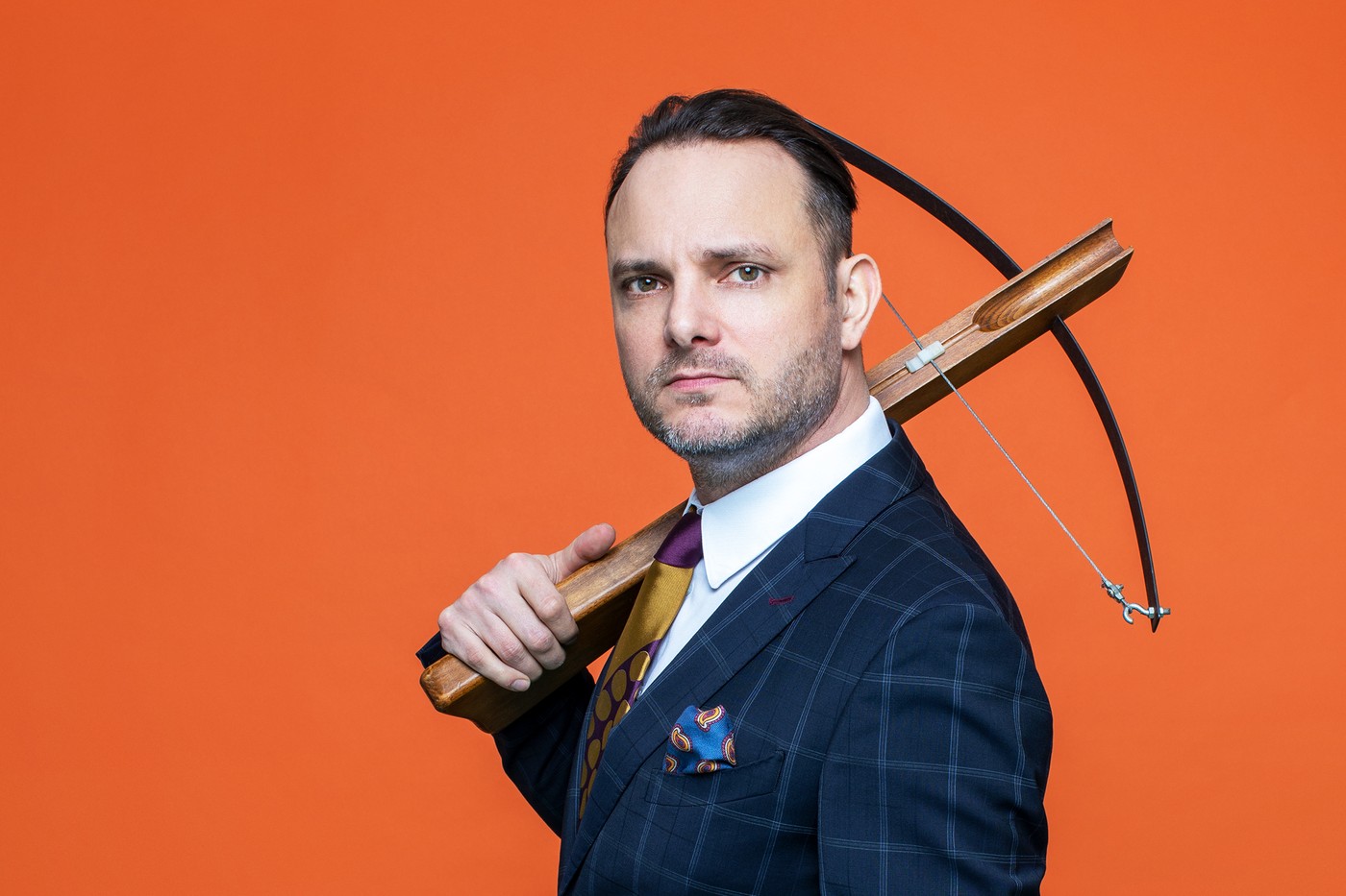 Dominic Deville mit einer Armbrust über der Schulter