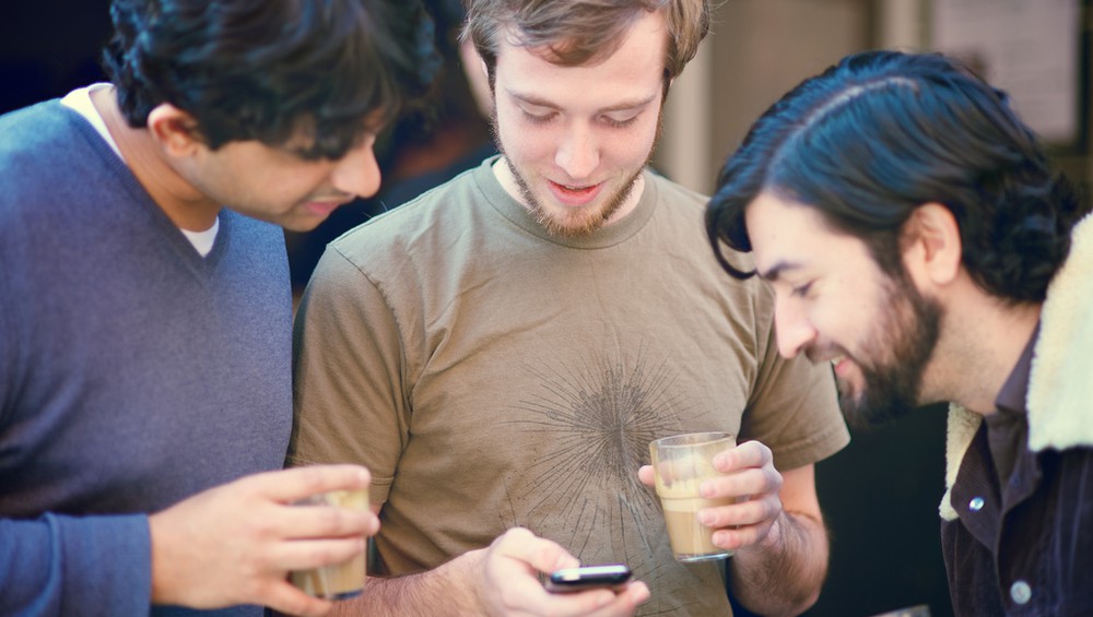 Männer schauen alle auf Handy