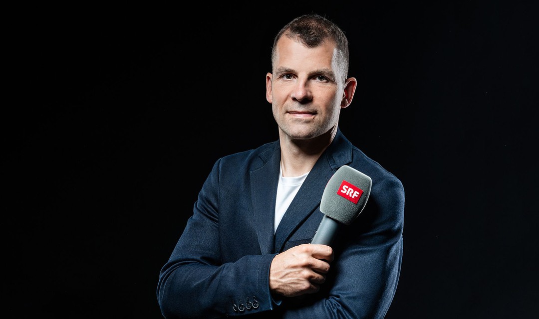 Porträt von Martin Plüss mit Mikrofon in der Hand