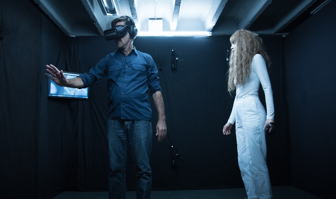 Ein Mann mit VR-Brille in einem dunklen Raum.