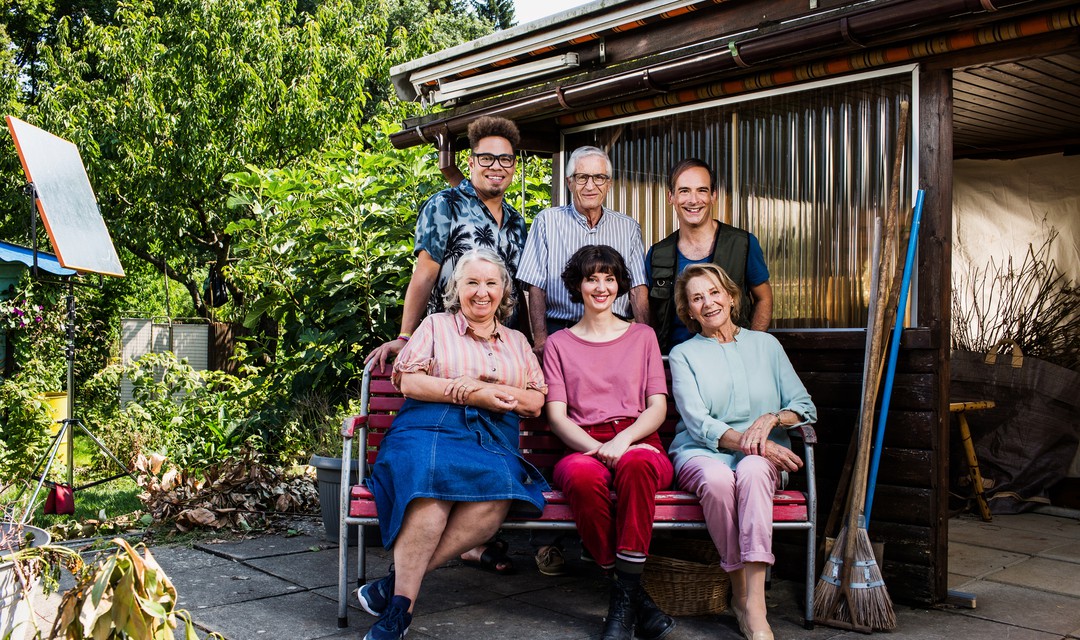 Der Cast des Schweizer FIlms Eden Einfach sitzt auf einer Bank im Garten