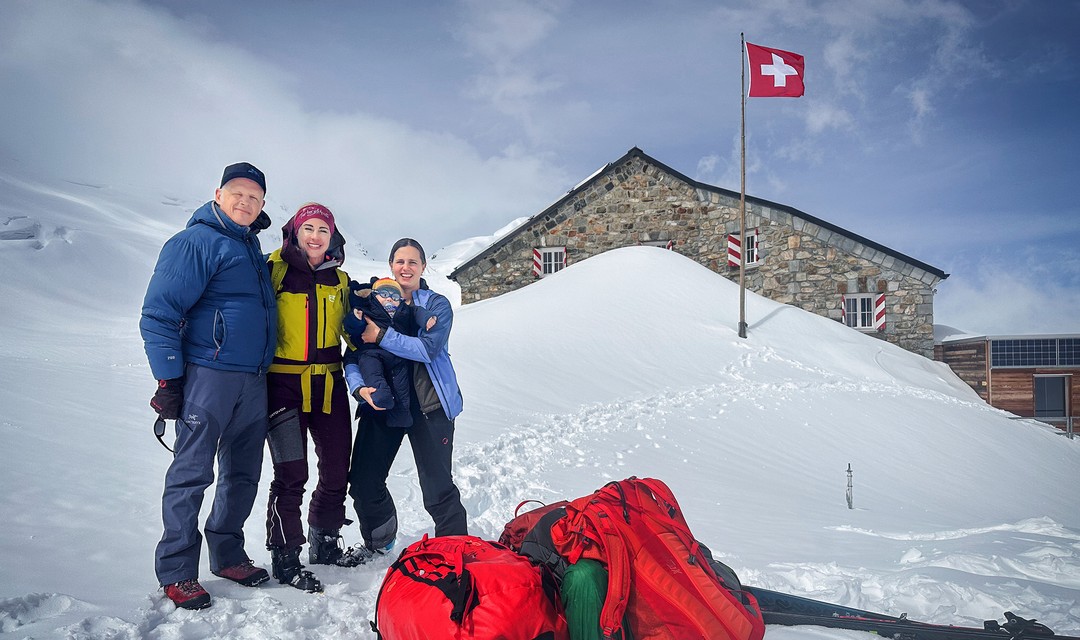 Nicole Berchtold steht mit einer Familie vor einer Berghütte