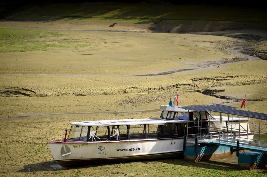 Schiff mit Aufschrift "nlb.ch" steht auf ausgetrocknetem Flussbett