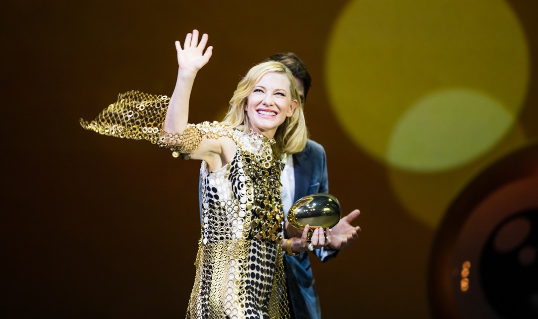 Cate Blanchett mit Preis in der Hand winkt
