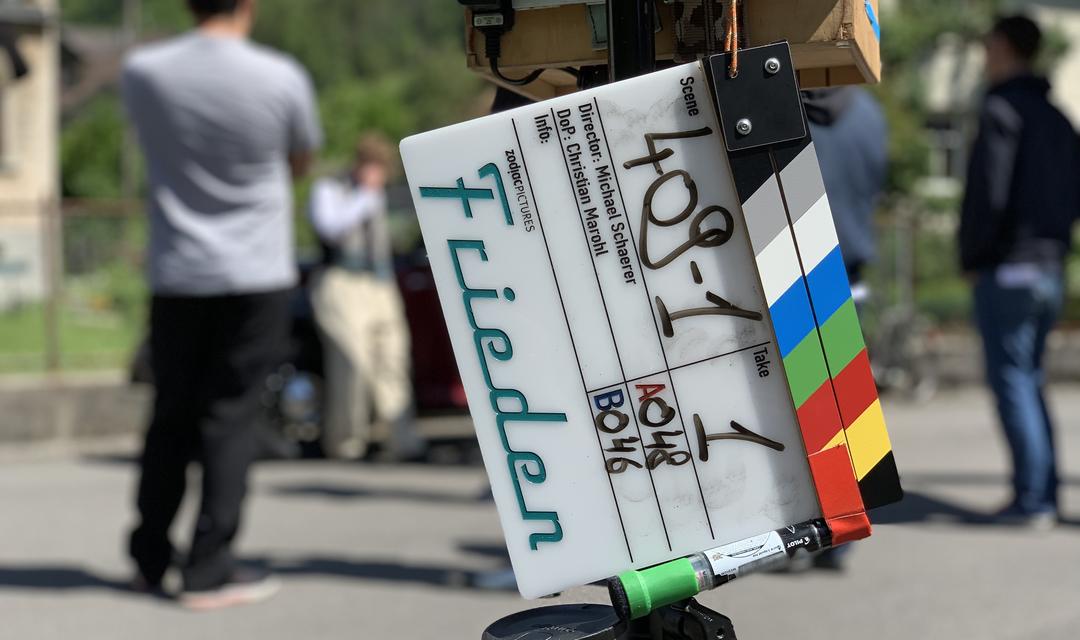 Filmklappe mit dem Schriftzug «Frieden» graviert. Hintergrund ist unscharf