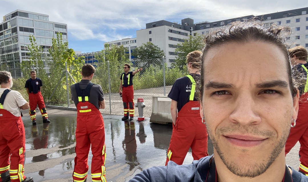 Selfie von Praktikant Jan mit der Betriebsfeuerwehr im Hintergrund