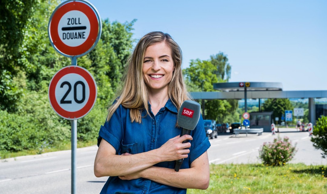 Katharina Locher steht vor einem Zollgebäude