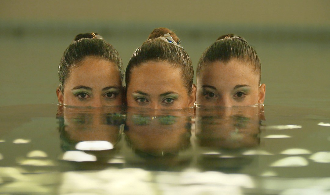 Foto von drei Synchronschwimmerinnen im Wasser