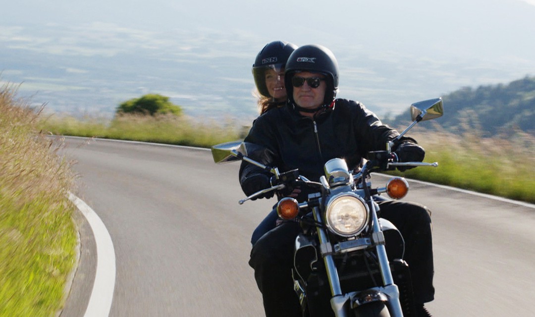 Ausschnitt aus Signes: Natasha Ruf fährt mit Christoph Staerkle auf dem Motorrad mit.
