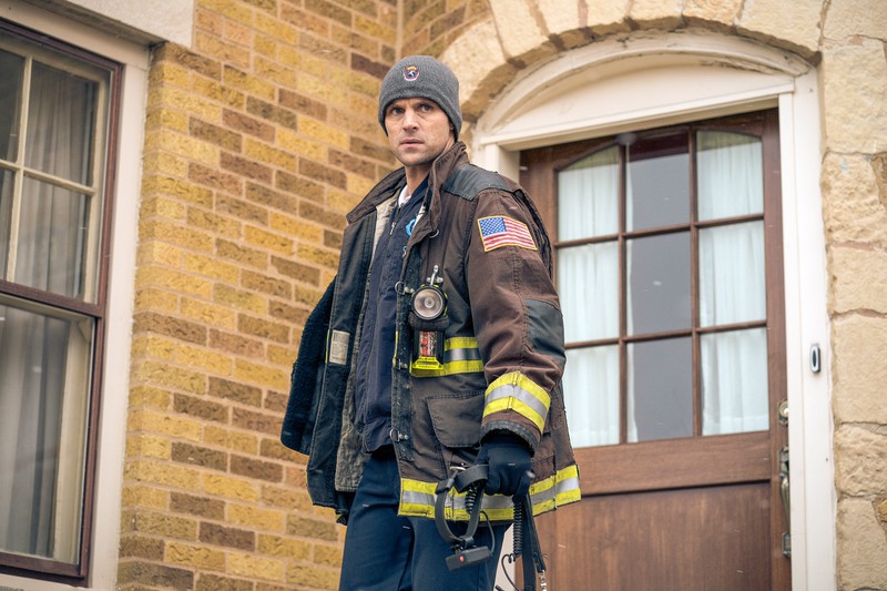 Ein Feuerwehrmann steht vor einem Haus.