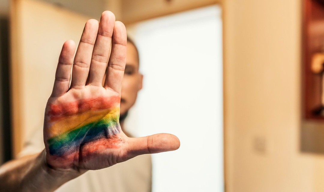 Eine Hand mit Regenbogenfarben.