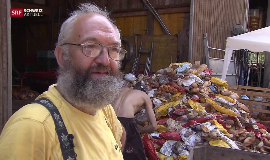 Kritisierter Pferdezüchter vor seinem Stall, im Hintergrund Berge von altem Brot