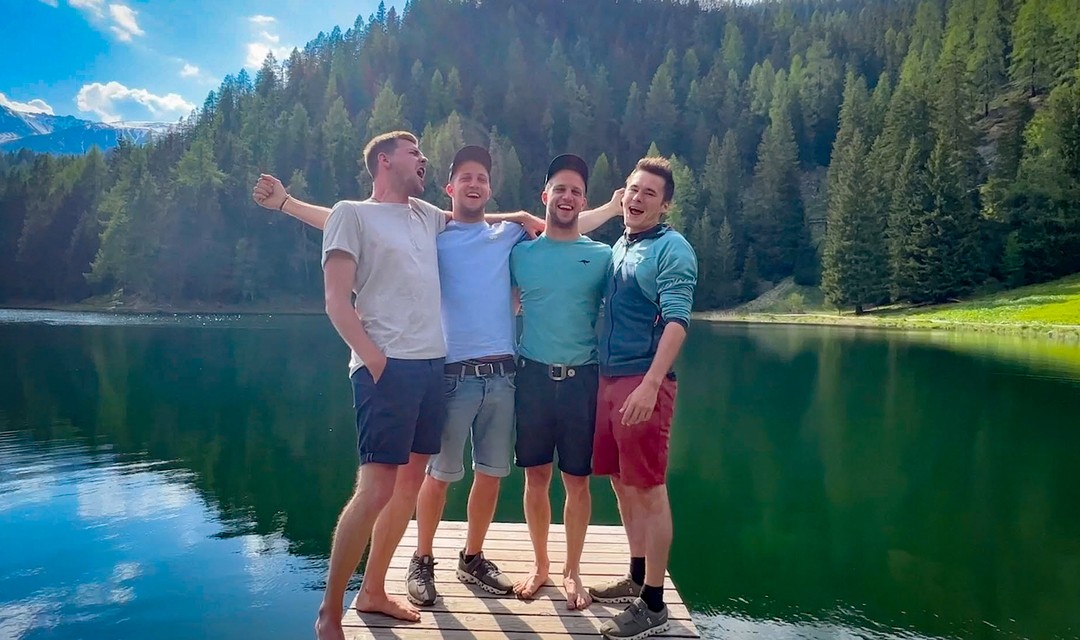 Foto: Niklaus Hess, Cyrill Rusch, Simon Rusch und Thomas Hegner stehen auf einem Steg an einem See