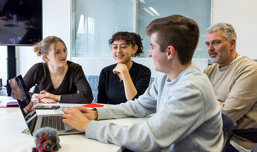 Einige Schüler:innen arbeiten mit Sandro Brotz an einer Sendung.