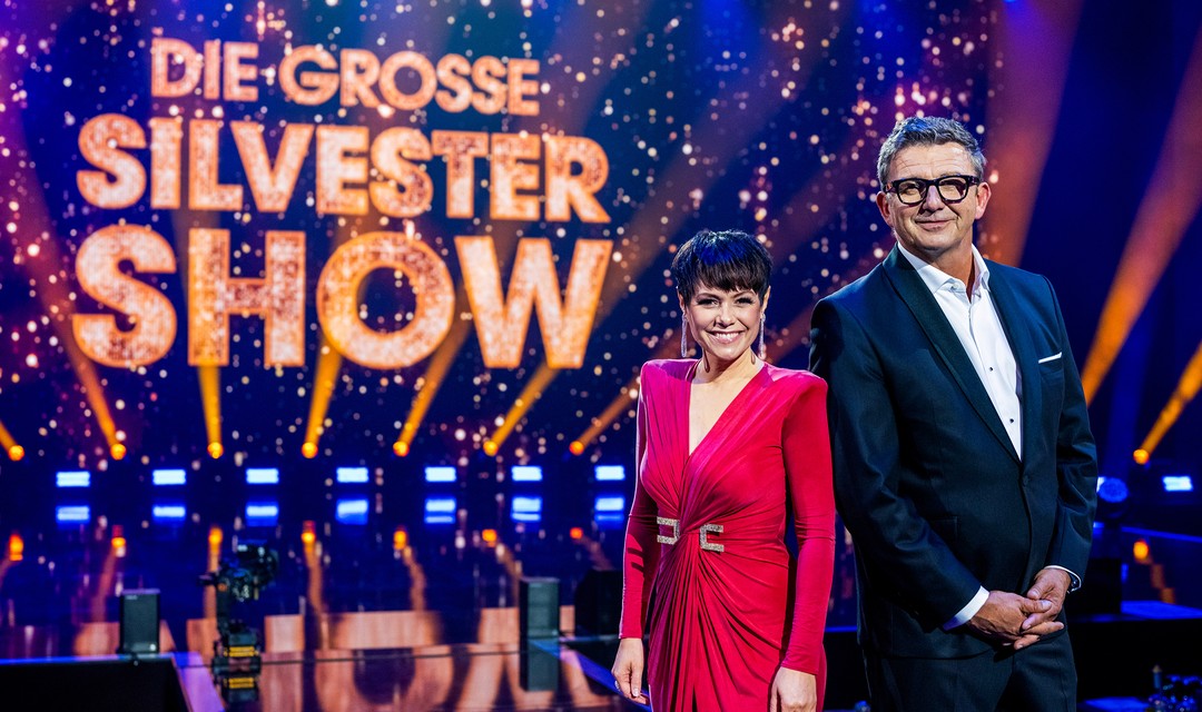 Das Moderations-Duo Francine Jordi und Hans Sigl steht vor dem leuchtenden Schriftzug «Die grosse Silvester Show»