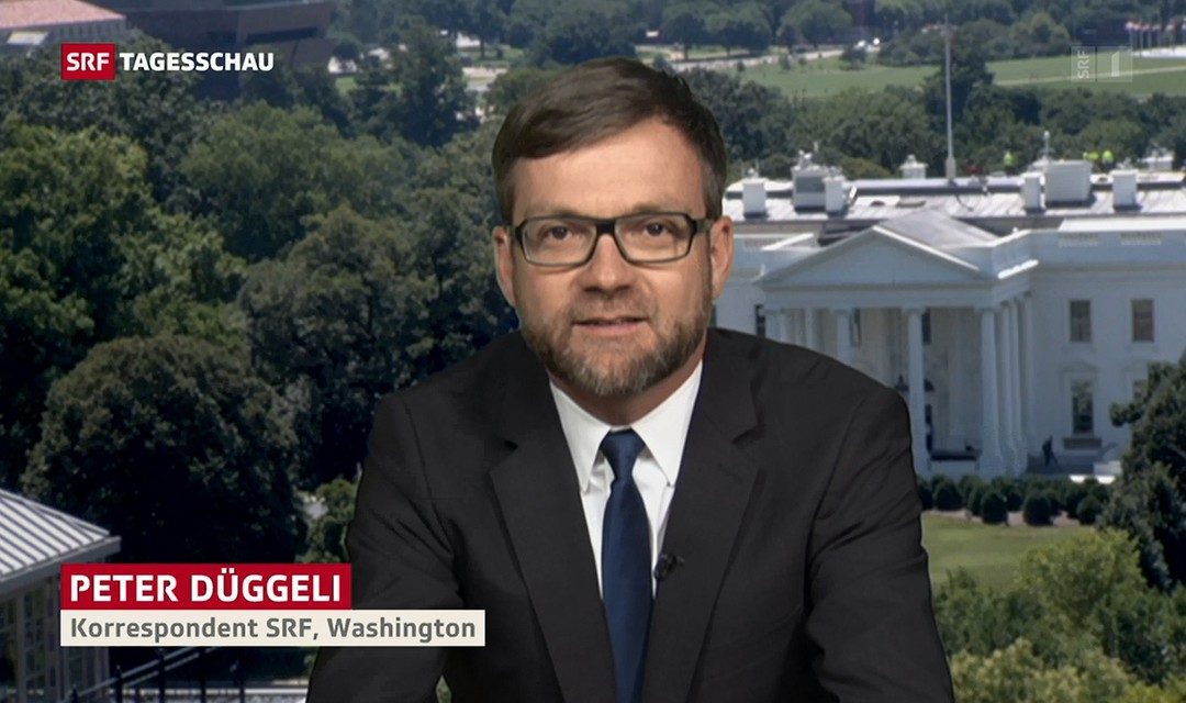 USA-Korrespondent Peter Düggeli, im Hintergrund ein Bild des Weissen Hauses in Washington