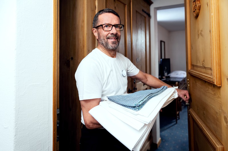 Ruedi Herzig bringt frisch gewaschene Wäsche in ein Hotelzimmer.