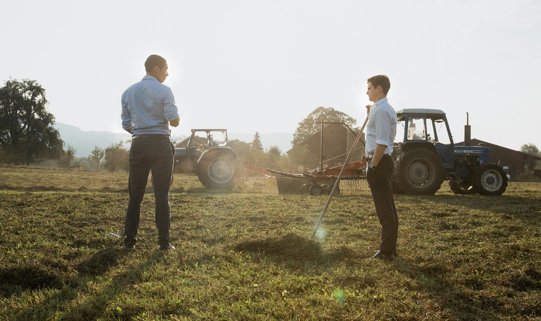Benito Bause als Joel Bachmann und Julian Koechlin als Michi Wyss beim Heuen im Anzug
