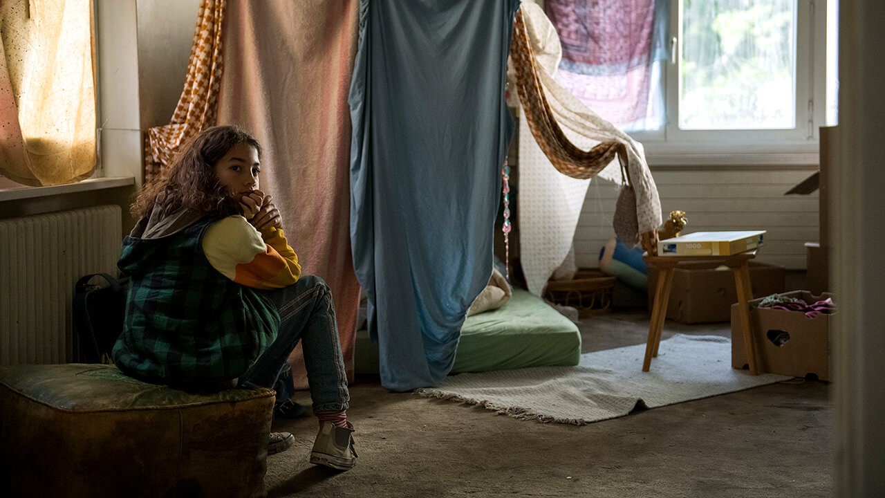 Die elfjährige Mia (Luna Mwezi) sitzt in ihrem Zimmer auf einem Hocker