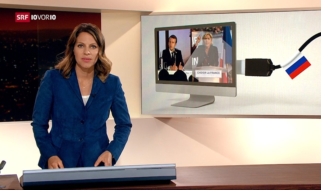 Moderatorin von 10vor10, im Hintergrund Bild in Computer von Macron und Le Pen mit russischem Fähnli an PC-Kabel
