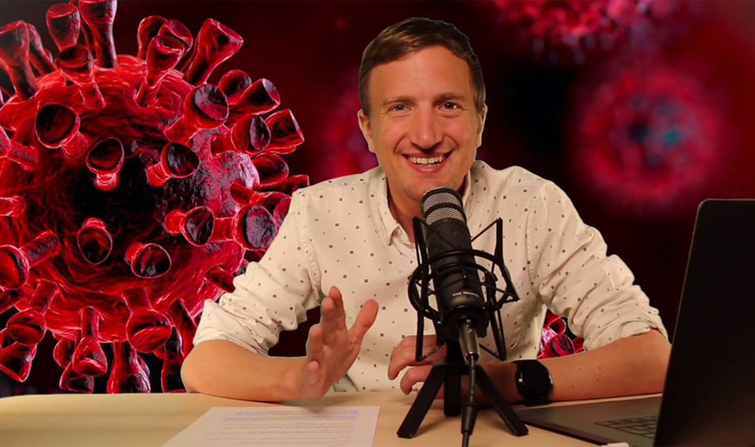 Stefan Büsser sitzt mit einem Mikrofon an einem Tisch