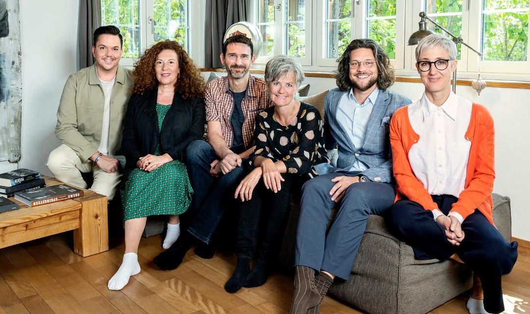 Moderator Sven Epiney mit den Kandidat:innen: Vanessa, Adrian, Gabriela, Angelo und Fabienne auf einem Sofa