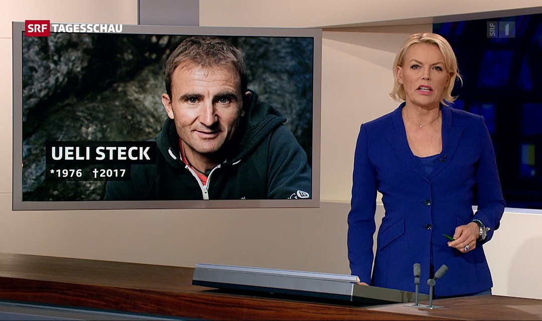 Moderatorin Katja Stauber im Studio, im Hintergrund Bild von Ueli Steck