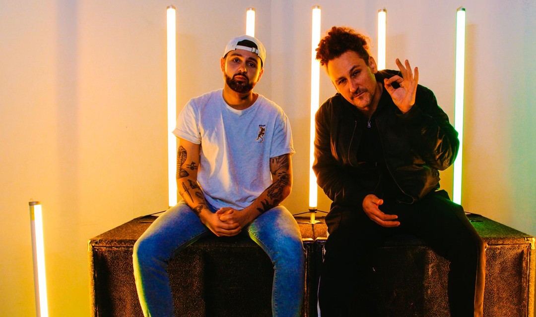 Die beiden Gastgeber Livio Carlin und Pablo Vögtli sitzen auf Musikboxen