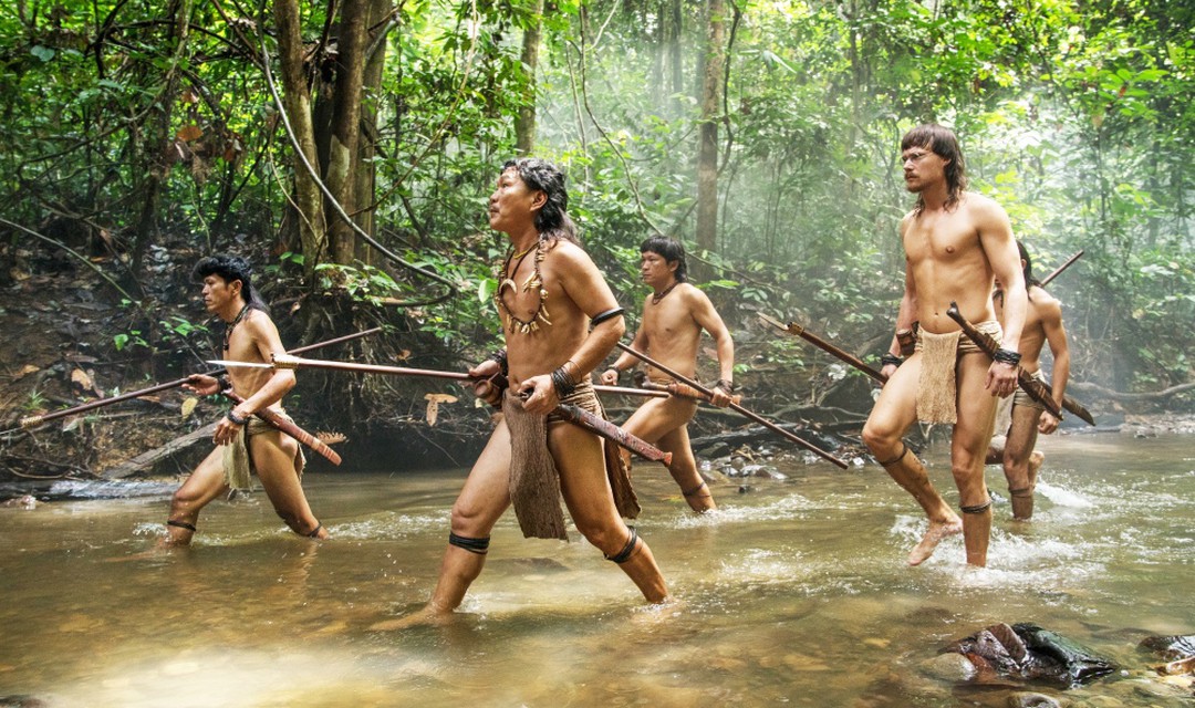 Bild aus dem Film Bruno Manser - die Stimme des Regenwaldes - Menschen laufen im Dschungel durch einen Fluss