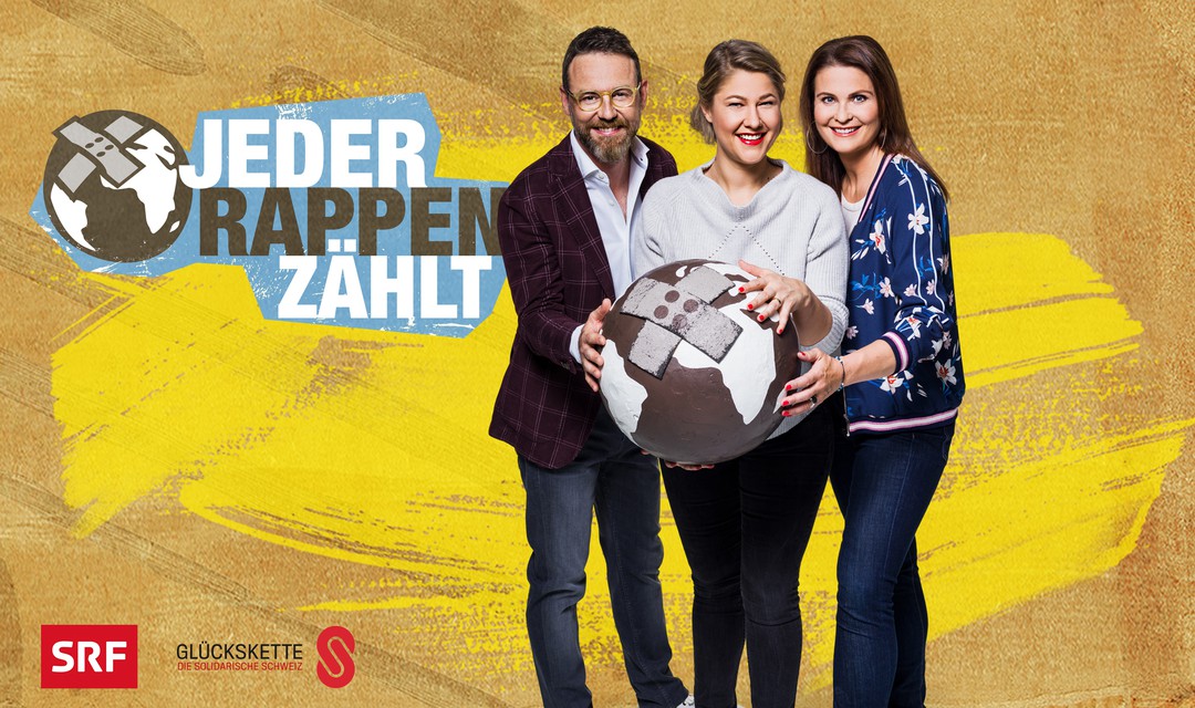 Visual zu «Jeder Rappen zählt» 2018. Nik Hartmann, Anic Lautenschlager und Judith Wernli halten einen Globus mit Pflaster