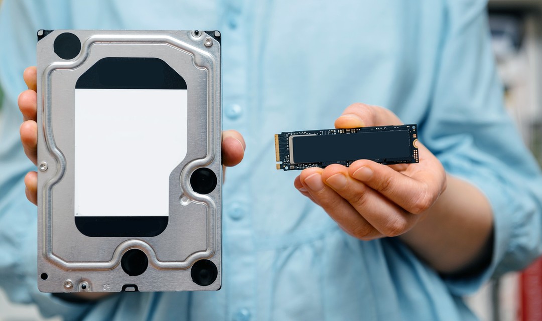 Eine Frau hält eine SSD-Festplatte in die Kamera, welche sie auseinandergenommen hat