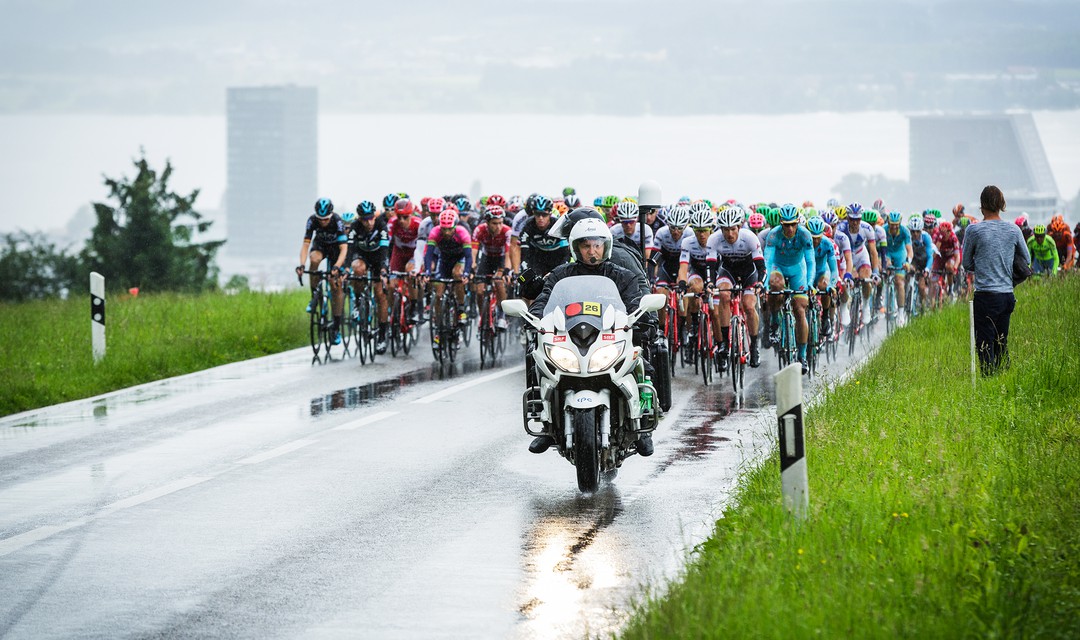 Kamera auf Motorrad an Tour de Suisse mit Radfahrern im Hintergrund