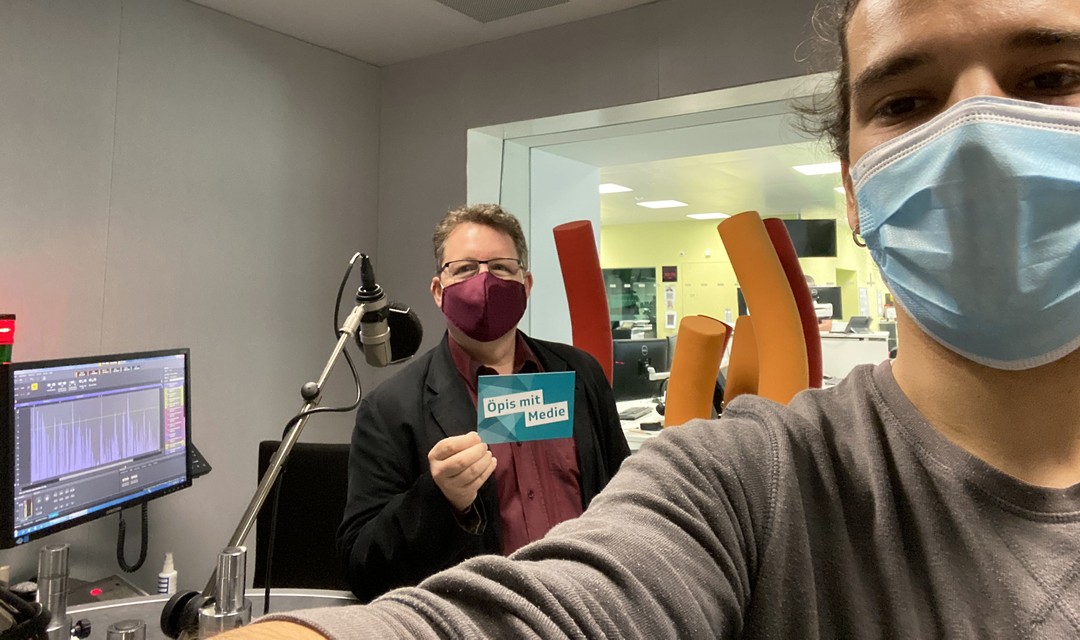 Praktikant Jan steht mit Philip Meyer im Radiostudio. Beide tragen Mundschutz und halten Abstand.