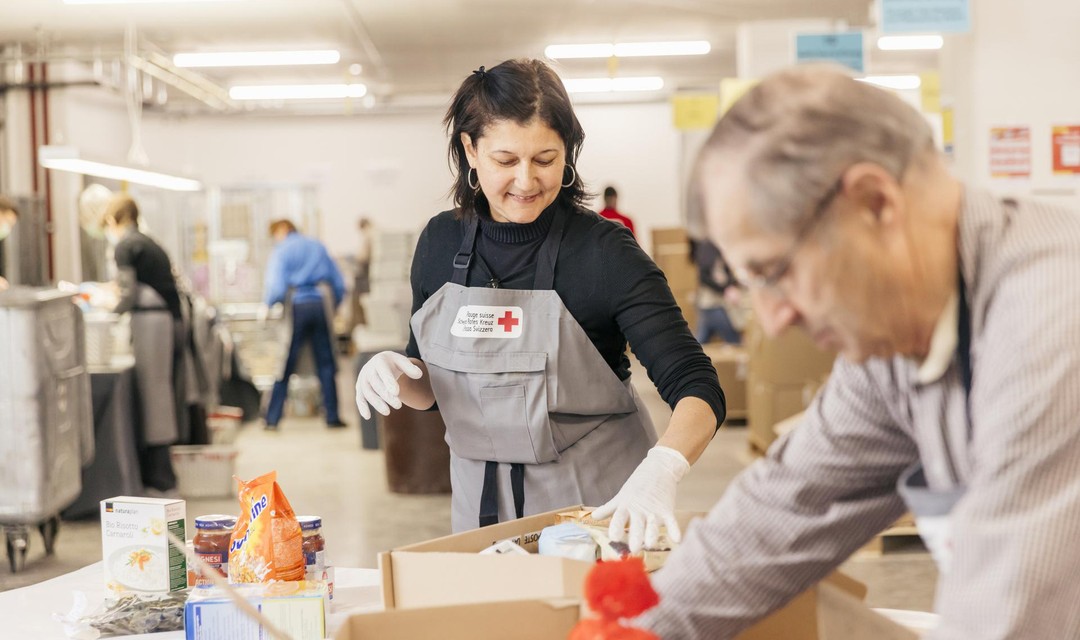 Eine Frau verpackt Lebensmittel in einem Verteilzenter