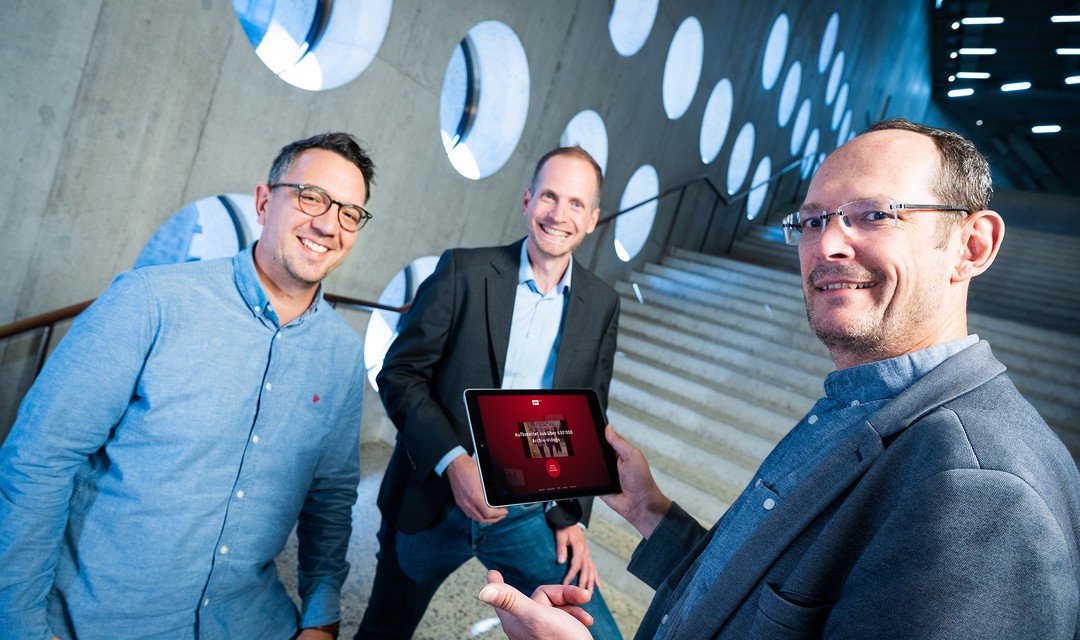 Stefan Weber, Kai Jauslin und Christian Vogg mit einem Tablet in der Hand