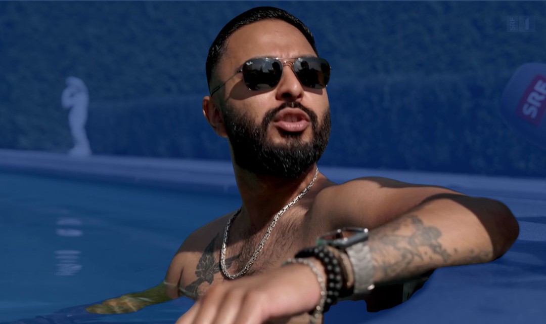 Mann mit Sonnenbrille, teurer Uhr, sitzt in Pool und hat Arm auf Poolkante