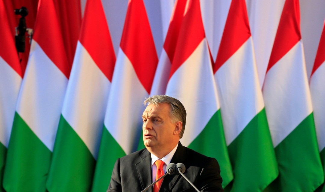 Wahlkampf in Ungarn: Ministerpräsident Viktor Orban steht am Rednerpult, im Hintergrund zahlreiche aufgestellte Ungarn-Fahnen