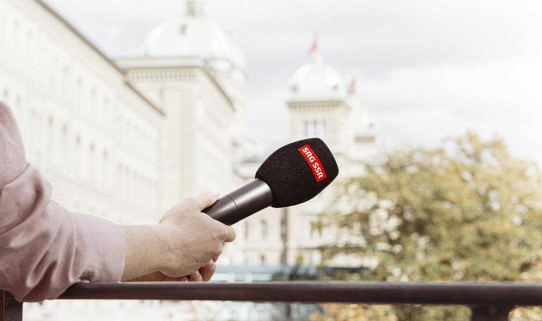 Foto: Eine Person hält ein SRF-Mikrofon in der Hand