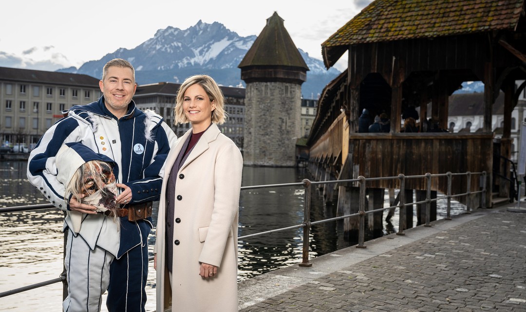 Foto: Die beiden Kommentatoren Sämi Deubelbeiss und Fabienne Gyr stehen vor der Kapellbrück in Luzern.